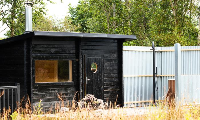 Wood-fired sauna in the meadow, with cold plunge and an outdoor shower
